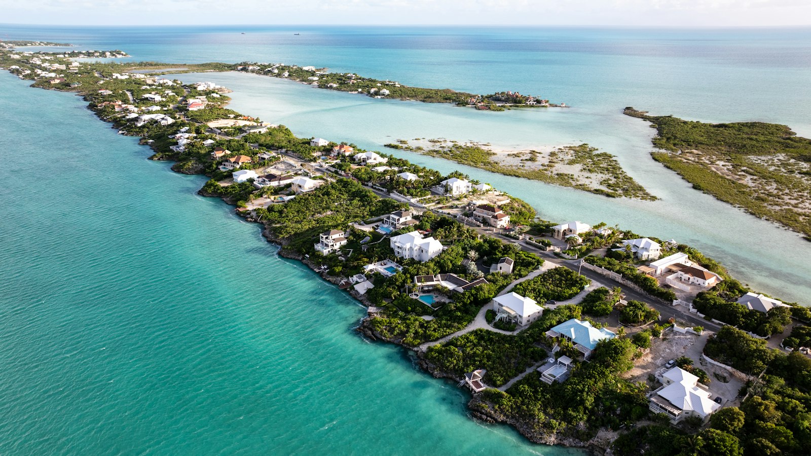 Aerial view of waterfront homes along a Turks and Caicos coastline