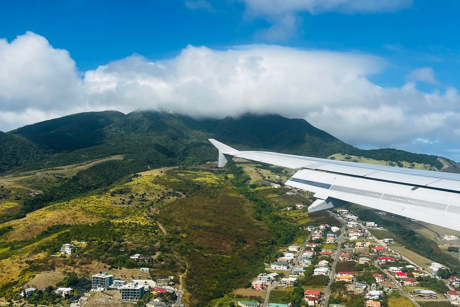 Aerial view of homes and hills on St Kitts from an aircraft window