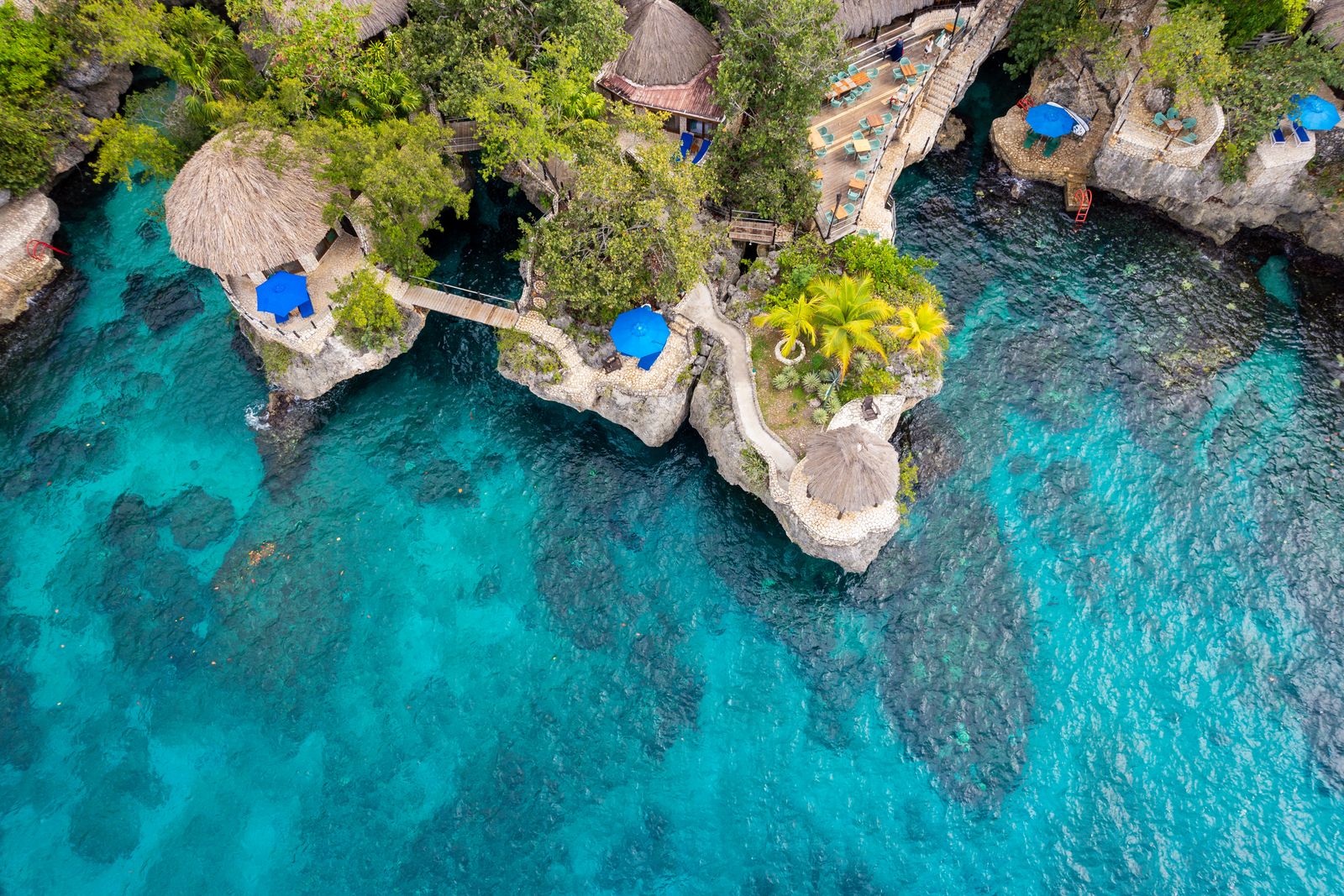 Aerial view of a cliffside resort above turquoise water in Negril, Jamaica