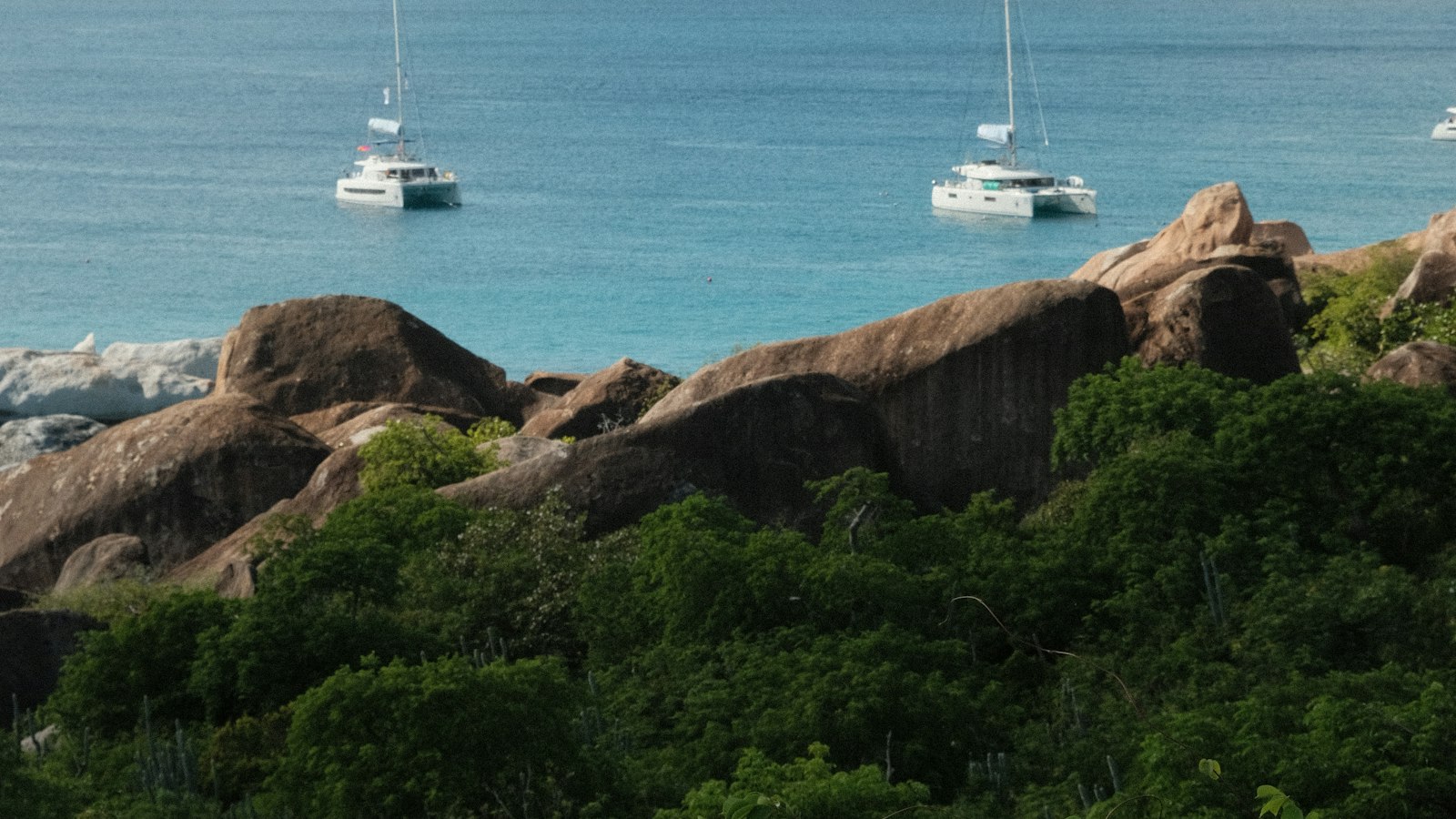 Sailing boats at anchor off the granite boulders of Virgin Gorda, British Virgin Islands