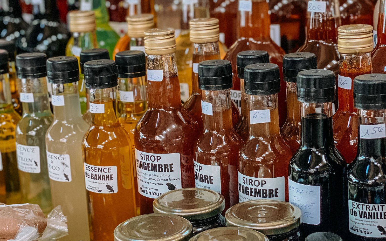 Bottles of local syrups and extracts on a market stall in Martinique